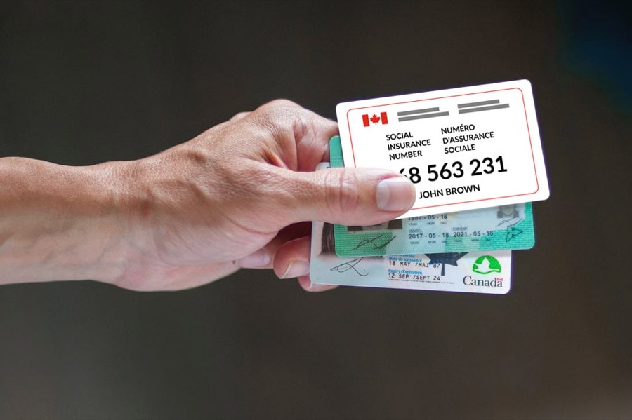 A hand holding a Canadian Social Insurance Number card